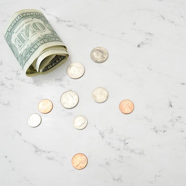 一美元美钞和硬币放在大理石桌上